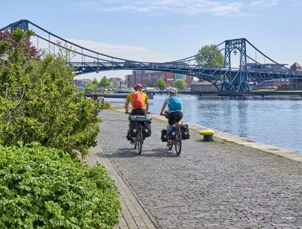 Radfahren mit Blick auf eine lange, graue Brücke