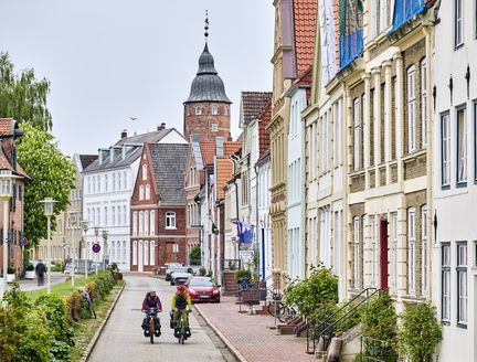 Radfahrende vor einer schönen Häuserreihe in Glückstadt