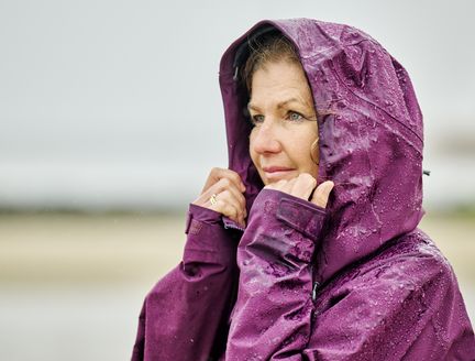 Frau lässt bei Regen den Blick in die Ferne schweifen