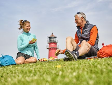 Mann und Frau picknicken auf dem Deich